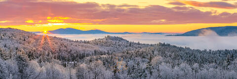 Fog blankets the lakes on a cold winter morning as the sun rises behind the Belknap mountains.