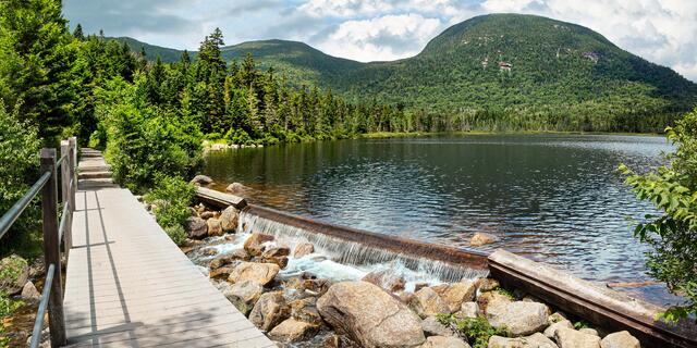 Lonesome Lake hiking trail and dam in summer.