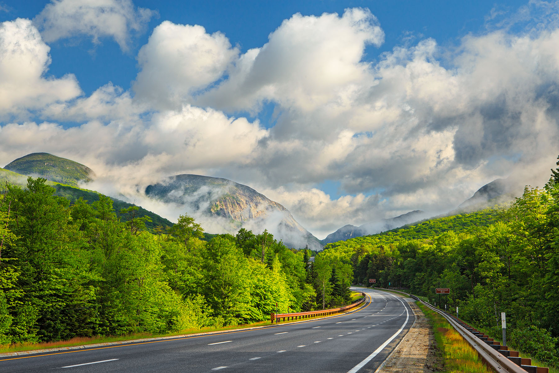 Beauty After the Storm, Franconia Notch Puffy storm clouds dapple the sky over Franconia Notch and the highway in the White Mountains of NH