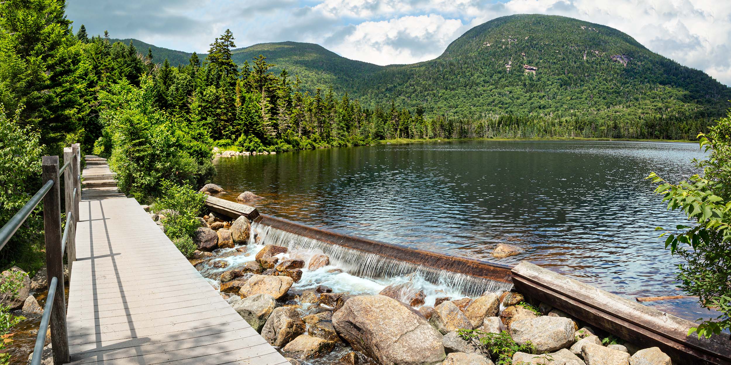 Lonesome Lake Dam Pano Lonesome Lake hiking trail and dam in summer.